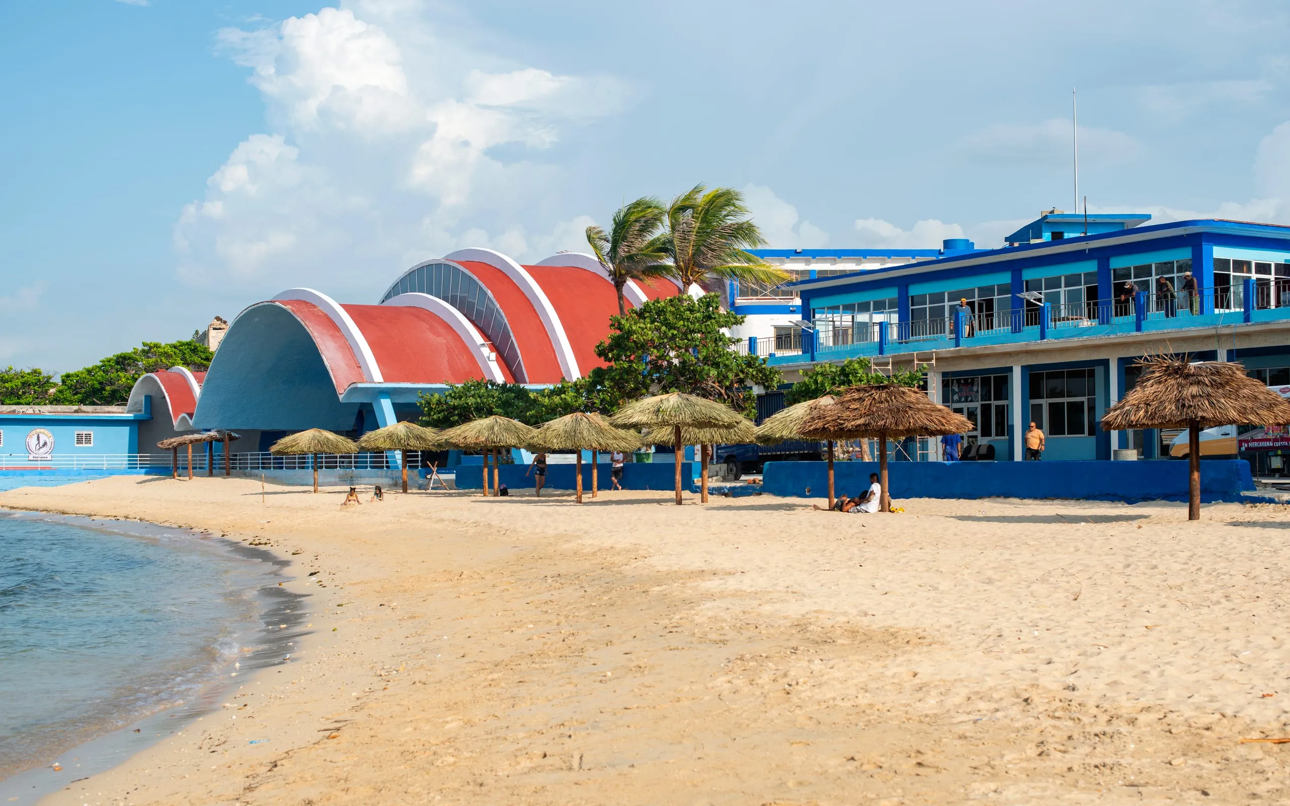 Playa con sombrillas y la cúpula del centro al fondo